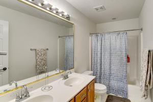 Un baño con lavabo, inodoro y espejo. en Des Moines Suburb Stay with Spacious Layout and Deck!, en Johnston 21 fotos más