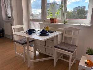 ブラチスラヴァにあるThe white Nest Apartment near City Centerのテーブル1脚、椅子2脚、テーブル1台、窓2つ