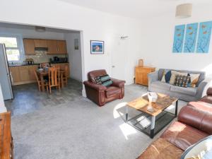 a living room with a couch and chairs and a table at Castleview Coastal Comfort in Oystermouth +21 photos