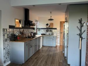 a kitchen with white cabinets and a wooden floor at Dom Na Wsi in Mierzwin Duży +22 photos