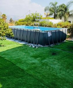 a large swimming pool with a ladder in a yard at לרניקה - יחידות אירוח in Qiryat Shemona