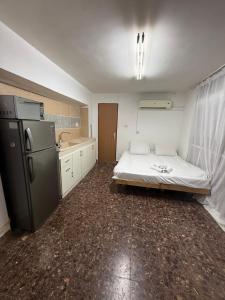 a room with a bed and a refrigerator in it at לרניקה - יחידות אירוח in Qiryat Shemona
