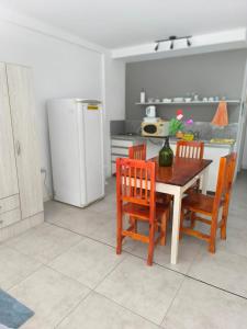 a kitchen with a table and chairs and a refrigerator at Monoambiente Zuly in San Miguel de Tucumán