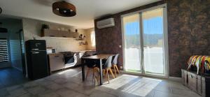 a kitchen with a refrigerator and a table with chairs at La Solentinamé in Reynès