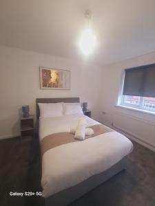 サウス・シールズにあるModern 3 bed Houseの白いシーツと窓のあるベッドのある寝室