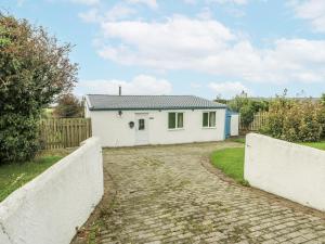 a white house with a fence and a driveway at Harbour Lights in Holyhead