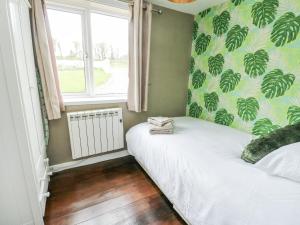a small bedroom with a bed and a window at Harbour Lights in Holyhead