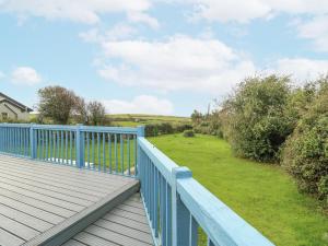 a deck with a blue railing and a yard at Harbour Lights in Holyhead +11 photos