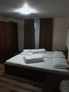 a bedroom with a bed with towels on it at Pensiunea Vânătorului in Miceşti