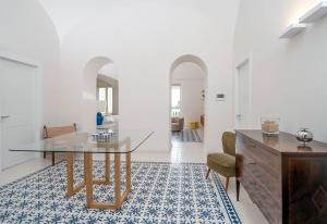 a dining room with a glass table on a blue and white rug at Certosa Luxury Apartment in Capri