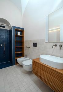 a bathroom with two sinks and a tub and a toilet at Certosa Luxury Apartment in Capri +8 photos