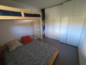 a bedroom with a bunk bed and white cabinets at appartement Superdevoluy in Superdevoluy