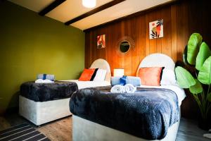 zwei Betten in einem Zimmer mit grünen Wänden in der Unterkunft Bright & Spacious 5-Bedroom Stay near Cambridge in Hardwick