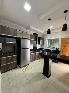 une grande cuisine avec des appareils électroménagers en acier inoxydable et une table dans l'établissement Casa Temporada Morumbi Anápolis Goiás, à Água Boa