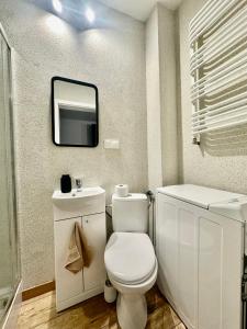 a bathroom with a toilet and a tv on the wall at klimatyczne Studio dla Par in Stanisławów Pierwszy