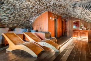 two benches in a room with a stone wall at Brieis Relais Alpino in Marmora
