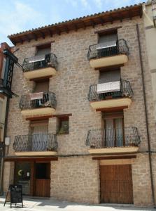 - un bâtiment en briques avec des balcons sur le côté dans l'établissement Fonda Angeleta, à Valderrobres
