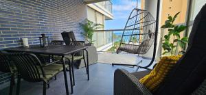 a black table and chairs on a balcony with a swing at Apartment Oceana - Luxury Sea View Beach Apartment in Calpe