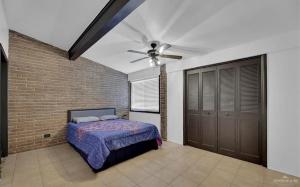 a bedroom with a bed and a ceiling fan at Charming 1BR Condo Near UTRGV & Downtown Edinburg in Edinburg