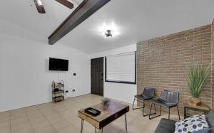 a living room with a couch and a brick wall at Charming 1BR Condo Near UTRGV & Downtown Edinburg in Edinburg