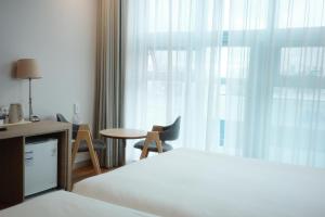 a hotel room with a bed and a table and a window at Rosana Hotel in Seoul