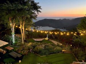a garden lit up at night with lights at Malibu Luxe 4BR with Panoramic views, Central location! in Malibu