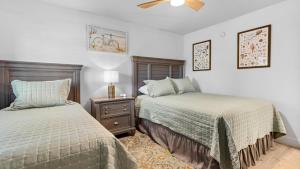 una camera da letto con due letti, un comodino e un ventilatore di Loggerhead Cay 451 a Sanibel Altre 32 foto