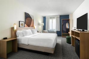 a hotel room with a bed and a flat screen tv at Spark by Hilton Toronto Mississauga in Mississauga