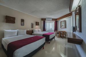 a hotel room with two beds and a table at Hotel Plaza Kokai Cancún in Cancún +44 photos