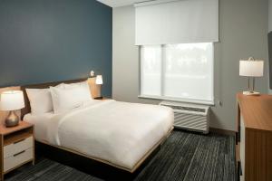 a hotel room with a bed and a window at TownePlace Suites by Marriott West Lafayette in West Lafayette