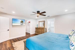 a bedroom with a blue bed and a ceiling fan at Banyan Beach House in Sanibel Island +40 photos