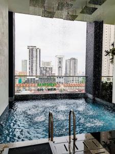 a large swimming pool with a view of a city at urban suites 3BR 10pax b30 infinity pool in Jelutong