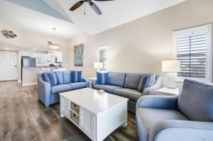 a living room with blue couches and a table at Shell Island Beach Club 7C in Sanibel