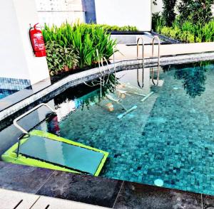 a swimming pool with a diving board in the water at urban suites 3BR 10pax b30 infinity pool in Jelutong +38 photos