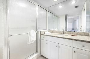a white bathroom with a shower and a sink at Shell Island Beach Club 7C in Sanibel