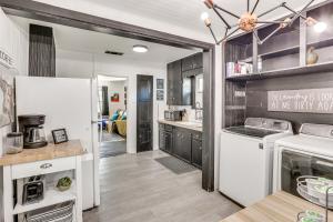 a kitchen with black cabinets and a white refrigerator at Time Machine Games Galore in Lubbock Home By TTU! in Lubbock