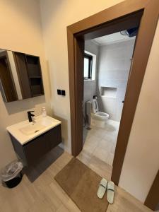 a bathroom with a sink and a toilet at شالية موج 335 in Dhahran +21 photos