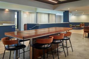 a bar in a room with stools around it at Courtyard by Marriott Atlanta Airport South/Sullivan Road in Atlanta