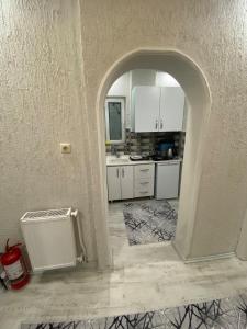 ブルサにあるPoyraz suitのアーチ型の入り口と白いキャビネットを備えたキッチン