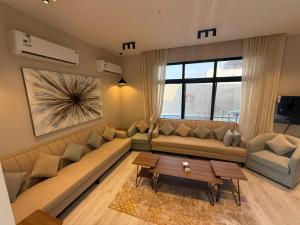 a living room with a large couch and a table at شالية موج 335 in Dhahran
