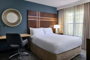 a bedroom with a bed and a desk and a chair at Residence Inn by Marriott Raleigh Crabtree Valley in Raleigh +23 photos