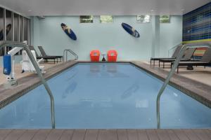 a swimming pool in a gym with benches and chairs at Aloft Hillsboro-Beaverton in Hillsboro