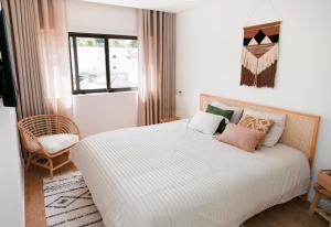 a bedroom with a bed and a chair and a window at In the heart of Ponte da Barca, cozy apartment in Ponte da Barca