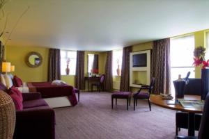 Una habitación de hotel con una cama y una sala de estar. en Manchester Airport Hotel by Dancenter, en Mánchester