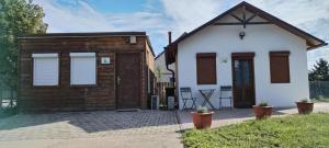 a small white and brown house with a patio at Lemon & Lime Apartmanok Mikepércs Debrecen közelében in Mikepércs