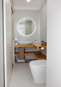 a bathroom with a white toilet and a mirror at In the heart of Ponte da Barca, cozy apartment in Ponte da Barca