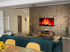 Una sala de estar con un sofá azul y una chimenea. en RakanStudioApart, en Timisoara