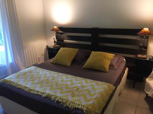 una camera con un grande letto con testiera in legno di La maison de caroline a Marcheprime