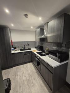 ブラッドフォードにあるCotswold Escape 15 - City Centreのキッチン(グレーのキャビネット、シンク、電子レンジ付)