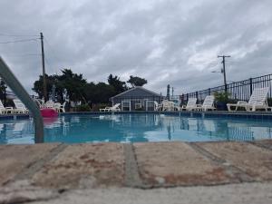 a large swimming pool with chairs and a fence at The Breezeway Motel & Resturant in Topsail Beach